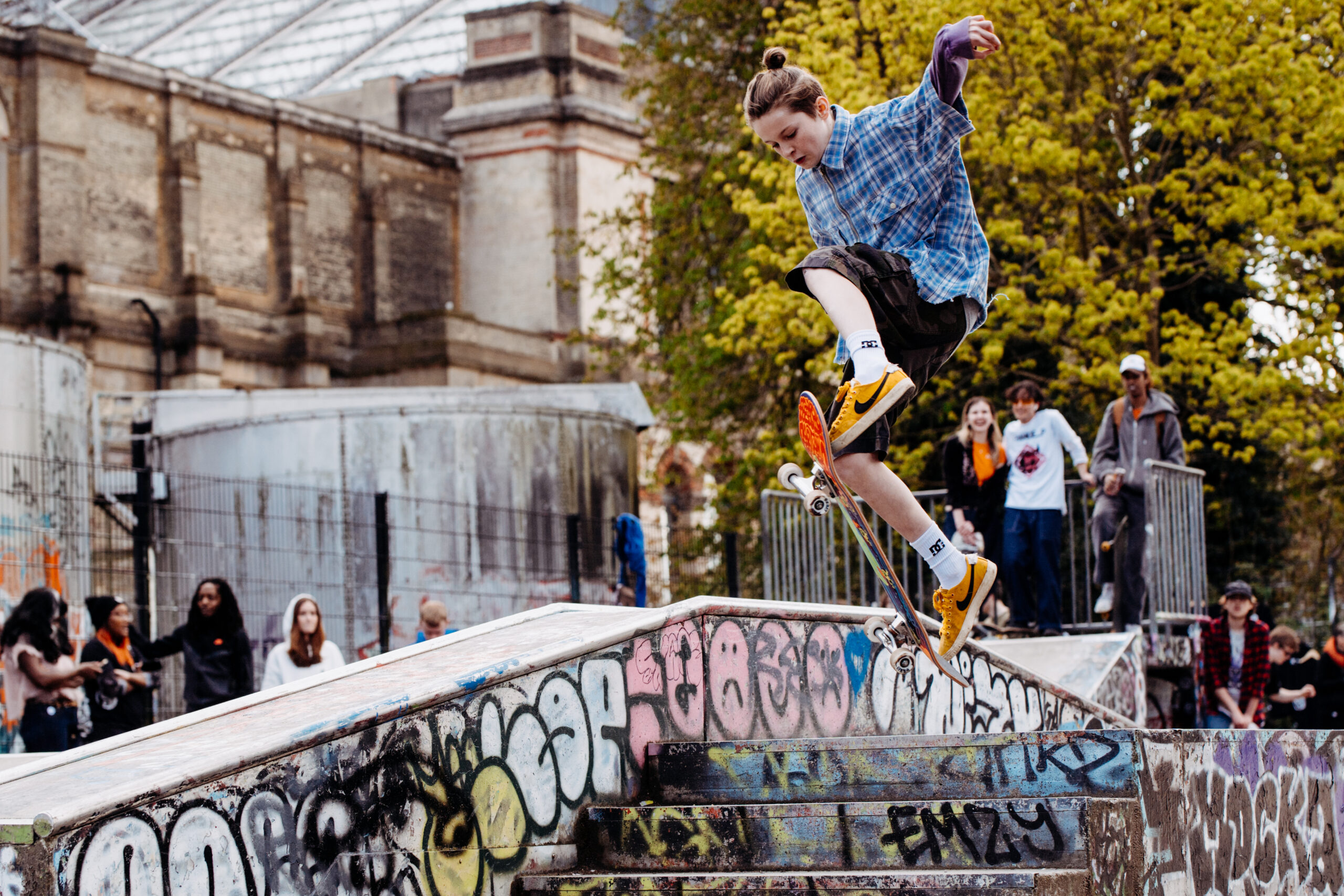 A skateboarder performs an impressive trick on a ramp at Skate Jam.